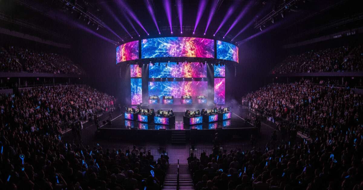 Esports arena with large screens and audience watching a gaming tournament